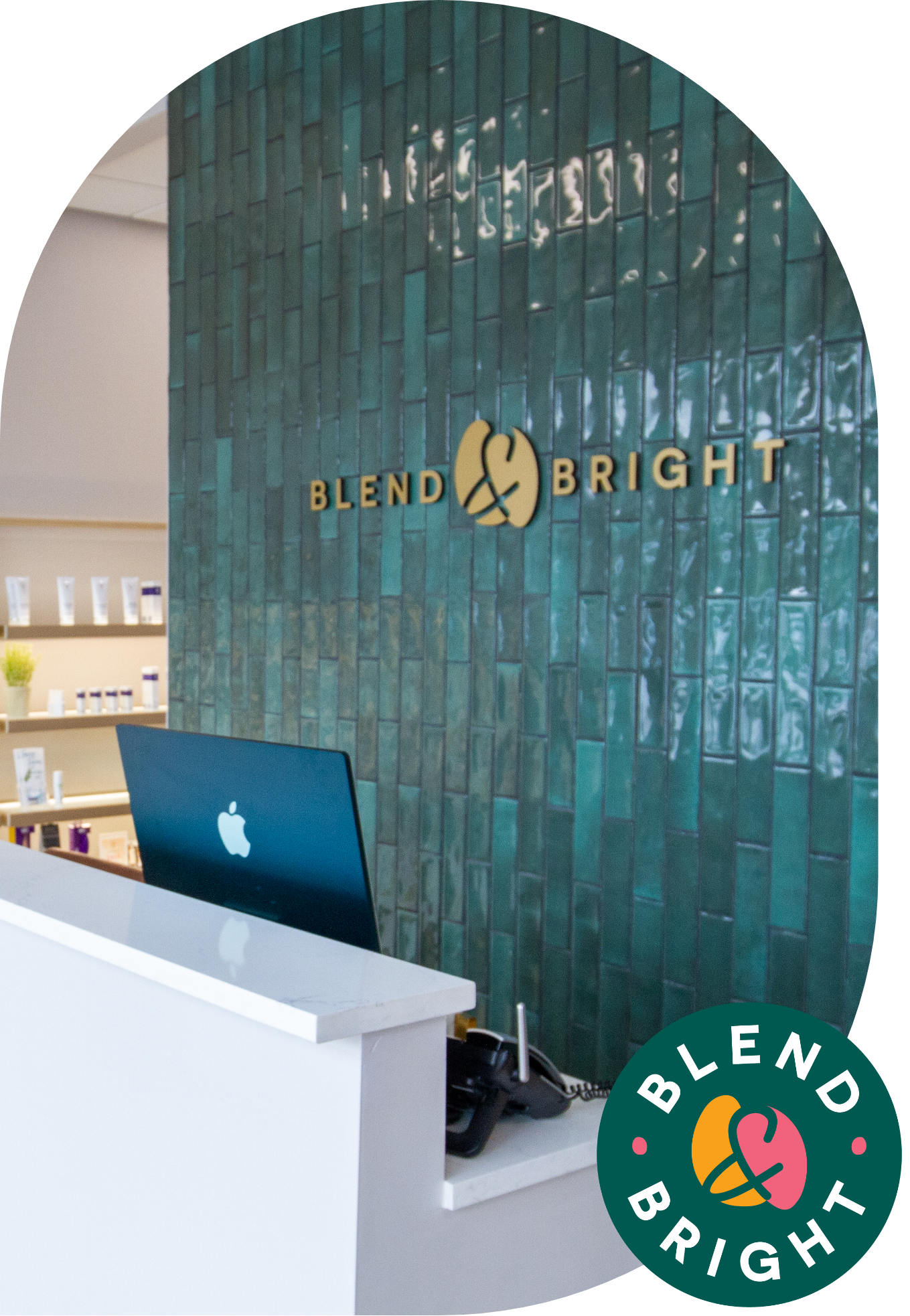 Blend & Bright front desk with gold logo on green tile and a white desk